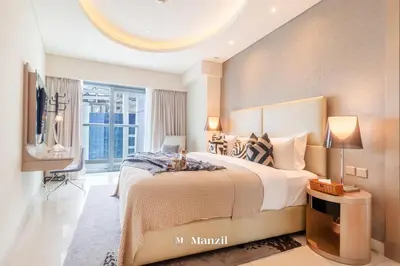 a bedroom with a large bed and a tv at Manzil - 1BR Apt with Pool close to Downtown in Dubai