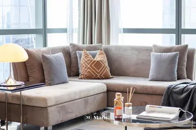 a living room with a couch with pillows on it at Manzil - 1BR Apt with Pool close to Downtown in Dubai