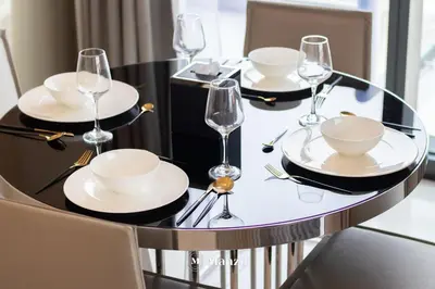 a black dining table with plates and glasses on it at Manzil - 1BR Apt with Pool close to Downtown in Dubai