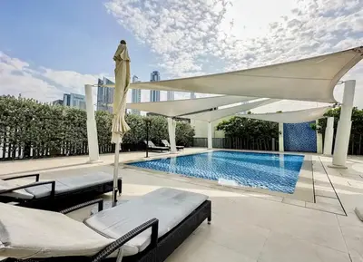 a swimming pool with a white canopy and chairs and a swimming pool at New Stunning 4 BR Burj Khalifa View in Dubai