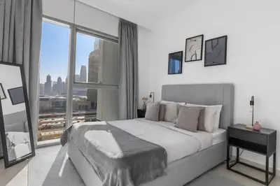 a bedroom with a large bed and a large window at New Stunning 4 BR Burj Khalifa View in Dubai