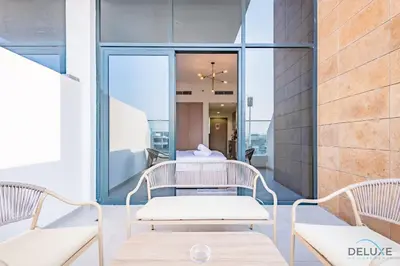 a balcony with two chairs and a table at Delightful Studio Apartment in Azizi Riviera 20, Al Merkadh by Deluxe Holiday Homes in Dubai
