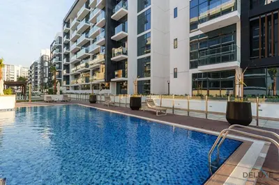 a large swimming pool in front of a building at Delightful Studio Apartment in Azizi Riviera 20, Al Merkadh by Deluxe Holiday Homes in Dubai
