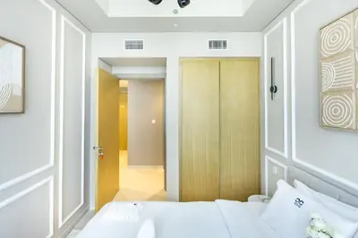 a bedroom with a white bed and a door at Cozy 1 BR apartment in Dubai near Burj khalifa in Dubai