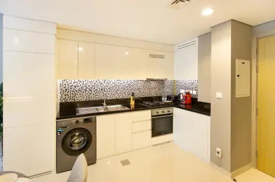 a kitchen with white cabinets and a dishwasher at Cozy 1 BR apartment in Dubai near Burj khalifa in Dubai