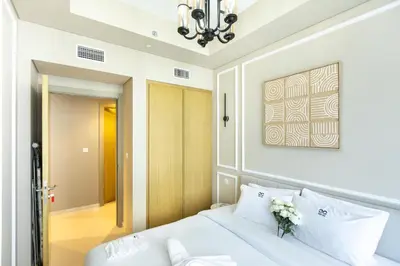 a bedroom with a white bed and a chandelier at Cozy 1 BR apartment in Dubai near Burj khalifa in Dubai