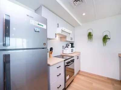 a kitchen with a stainless steel refrigerator and white cabinets at Stylish One Bedroom Sanctuary in the Greens in Dubai