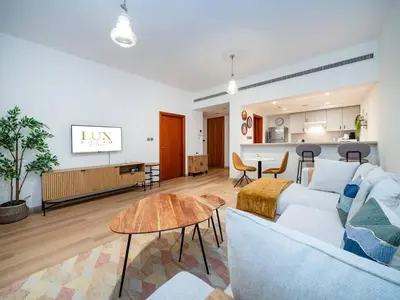 a living room with a couch and a table at Stylish One Bedroom Sanctuary in the Greens in Dubai