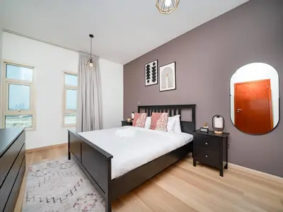 a bedroom with a large bed and a mirror at Stylish One Bedroom Sanctuary in the Greens in Dubai