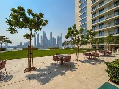 a patio with tables and chairs with a view of the city at Frank Porter - Marina Vista Tower 2 in Dubai
