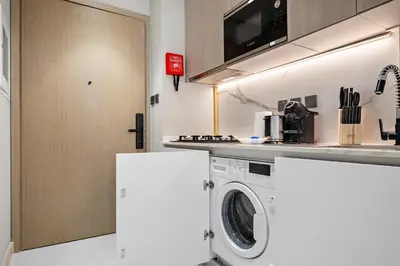a kitchen with a washing machine in a kitchen at StoneTree - Modern Apartment - Brand New in Dubai