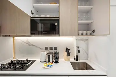 a kitchen with a stove and a microwave at StoneTree - Modern Apartment - Brand New in Dubai
