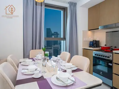 a dining room with a table with chairs and a kitchen at Top Floor Home with Amazing City Views 188BC-2 in Dubai