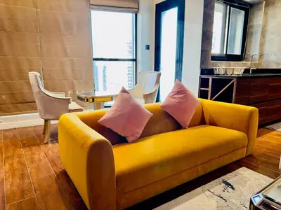 a yellow couch with pink pillows in a living room at Sea Front Living, Upgraded 2BR Apartment, Escan Tower, Dubai Marina in Dubai