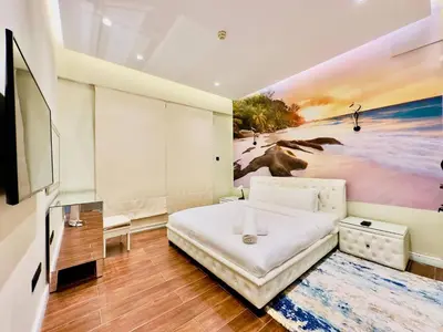 a bedroom with a bed and a painting of a beach at Sea Front Living, Upgraded 2BR Apartment, Escan Tower, Dubai Marina in Dubai