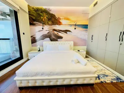 a bedroom with a bed with a painting on the wall at Sea Front Living, Upgraded 2BR Apartment, Escan Tower, Dubai Marina in Dubai