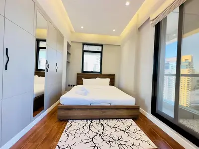 a bedroom with a bed and a large window at Sea Front Living, Upgraded 2BR Apartment, Escan Tower, Dubai Marina in Dubai