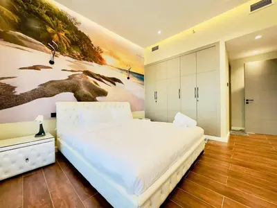 a bedroom with a white bed and a painting on the wall at Sea Front Living, Upgraded 2BR Apartment, Escan Tower, Dubai Marina in Dubai