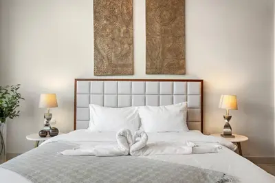a bed with white towels on it with two lamps at FIRST CLASS 1BR Burj Khalifa & Fountain Views in Dubai