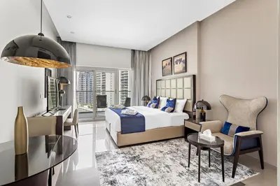 a bedroom with a bed and a living room with a table at Spacious Studio in Business Bay in Dubai