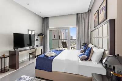 a bedroom with a large bed and a television at Spacious Studio in Business Bay in Dubai