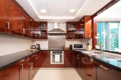 a kitchen with wooden cabinets and a stove top oven at Elite Royal Apartment - Full Burj Khalifa & Fountain View - Luxury Edition - Strategos in Dubai