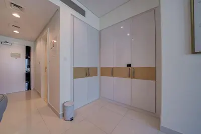 a walk in closet with white cabinets and a trash can at Business Bay Studio in hotel l Sleek & Modern for 2 in Dubai