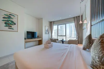 a bedroom with a large white bed with a large window at Business Bay Studio in hotel l Sleek & Modern for 2 in Dubai