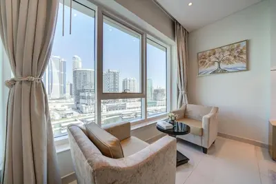 a living room with a couch and a large window at Business Bay Studio in hotel l Sleek & Modern for 2 in Dubai