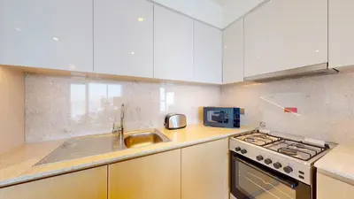 a kitchen with a sink and a stove top oven at Vacationer I Modern 1 Bed High-Floor Stay I City Skyline View I Burj Royale I Downtown in Dubai