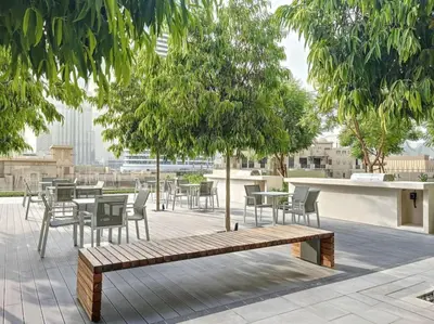a park with tables and chairs and a bench at Vacationer I Modern 1 Bed High-Floor Stay I City Skyline View I Burj Royale I Downtown in Dubai