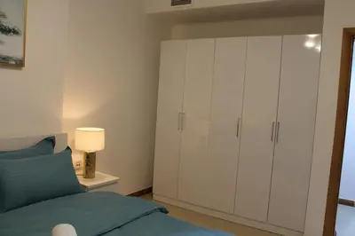 a bedroom with a bed and a white cabinet at Bright and beautiful one bedroom apartment close to metro and beach in Dubai