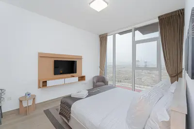 a bedroom with a bed and a large window at Escape24 Cozy Studio with City View in JVC in Dubai
