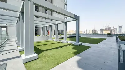a view of a building with green grass at Escape24 Cozy Studio with City View in JVC in Dubai