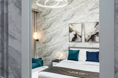 a bedroom with two beds and a stone wall at Escape24 Cozy Studio with City View in JVC in Dubai