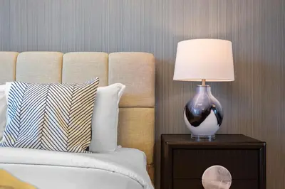 a lamp on a night stand next to a bed at Stylish Studio with Premium Features in Marina in Dubai