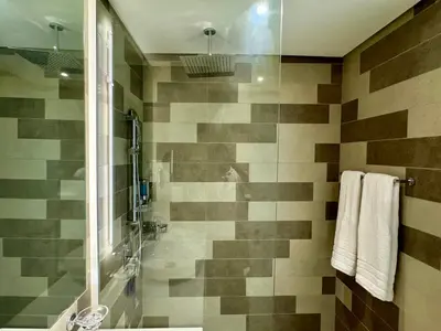 a bathroom with a shower and a tub at Hospitality Expert 7 Palm Studio - Beach Pool Bar in Dubai
