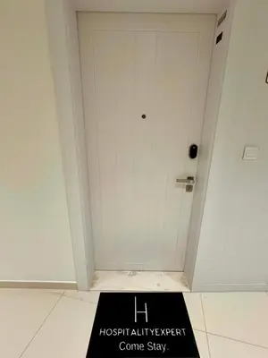 a black sign in front of a white door at Hospitality Expert 7 Palm Studio - Beach Pool Bar in Dubai