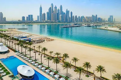 a view of a beach with palm trees and a city at Hospitality Expert 7 Palm Studio - Beach Pool Bar in Dubai