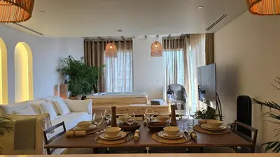 a living room with a table and a couch at Luxury 2BR Biophilic Retreat with Private Jacuzzi, Massage Chair & Infinity Pool in Dubai