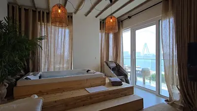 a bath tub in a room with a large window at Luxury 2BR Biophilic Retreat with Private Jacuzzi, Massage Chair & Infinity Pool in Dubai