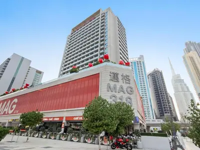 a large building in a city with tall buildings at FIRST CLASS Studio Stylish Haven in Dubai