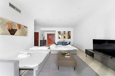 a living room with white furniture and a flat screen tv at FIRST CLASS 2BR Elite Urban Retreat in Dubai