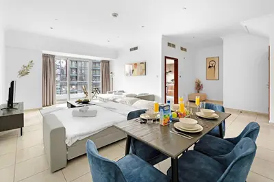 a living room with a bed and a table and chairs at FIRST CLASS 2BR Elite Urban Retreat in Dubai
