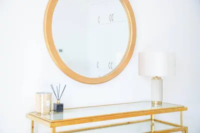 a round mirror above a console table with a lamp at Marina Tower - Stunning 1BHK with Marina View by Elegant Escape's in Dubai