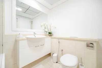 a white bathroom with a toilet and a sink at Marina Tower - Stunning 1BHK with Marina View by Elegant Escape's in Dubai