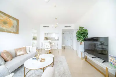 a white living room with a couch and a tv at Marina Tower - Stunning 1BHK with Marina View by Elegant Escape's in Dubai
