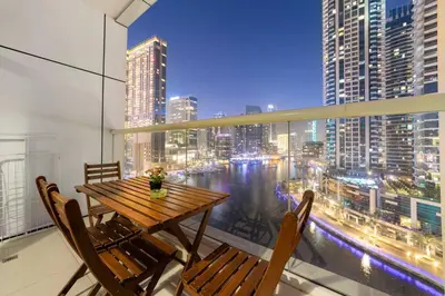 a table and chairs on a balcony with a view of a city at Luxury 2BR with Stunning Dubai Marina Views Near JBR Beach in Dubai