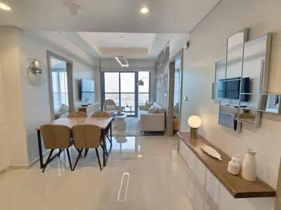 a dining room and living room with a table and chairs at Upgraded Downtown Dubai 2 BD in Dubai