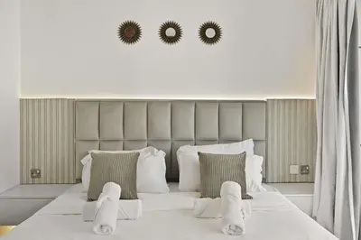 a bedroom with a large bed with two mirrors on the wall at Incredible downtown location in Dubai